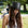 Woman wearing a black top hat outdoors with blurred background