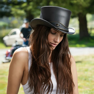 Woman wearing a black top hat outdoors with blurred background