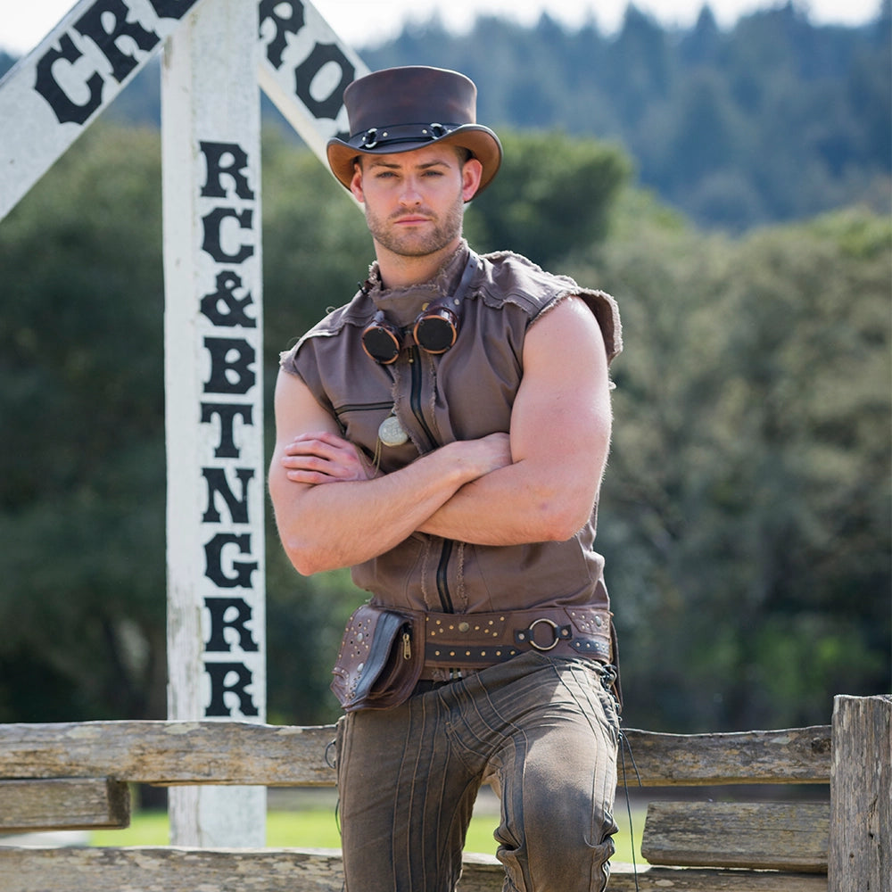 Man in a cowboy outfit standing in front of a wooden fence with a blurred background