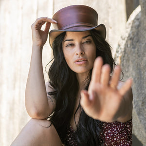 Woman wearing a brown leather hat with a blurred background