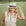Woman wearing a white hat and beige sleeveless top on a golf course