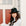 Woman wearing a black hat and white sweater in front of a door with red panels.