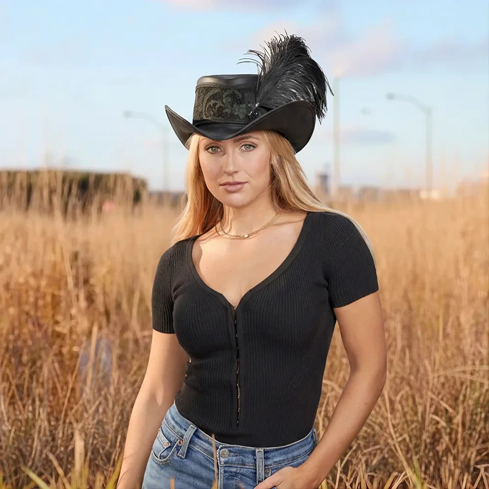 Woman wearing a black cowboy hat with feathers in an outdoor setting