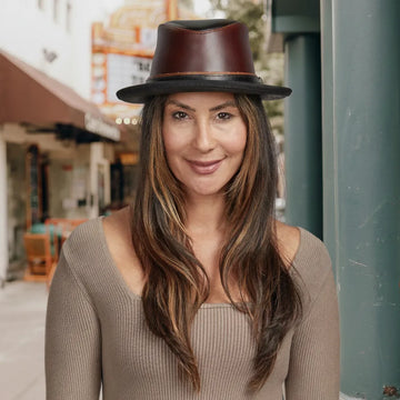 Woman wearing a brown leather hat in an urban setting