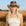 Woman wearing a cowboy hat in a field with a clear sky