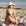 Woman in a black and white bikini sitting on a towel at the beach.