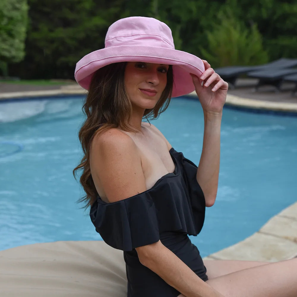 Woman wearing a pink hat by a pool