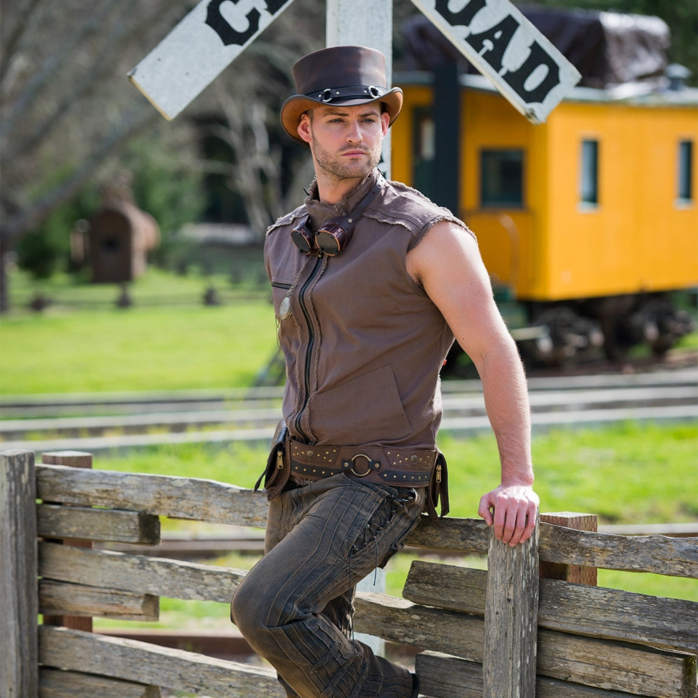 Man in cowboy attire leaning against a wooden fence with a train in the background