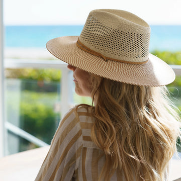 Person wearing a straw hat with a scenic background