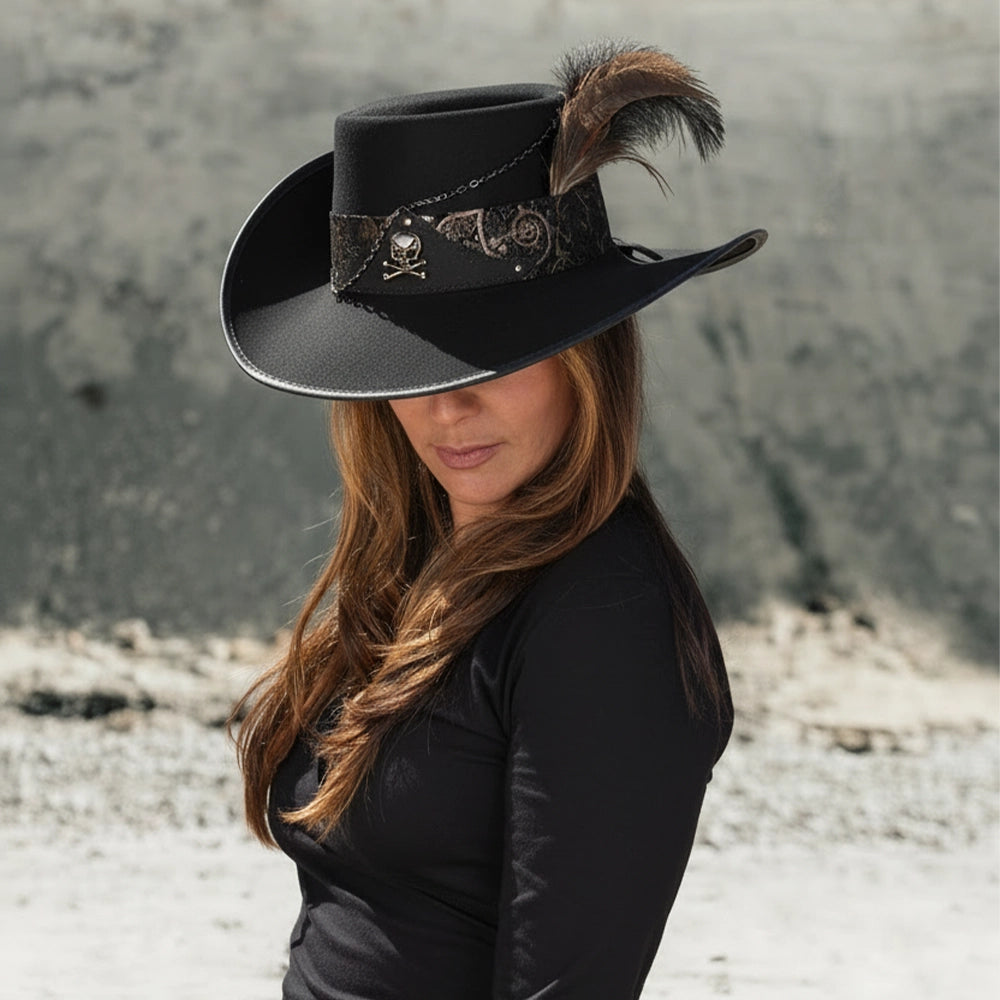 Person wearing a black cowboy hat with a feather against a textured wall.