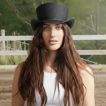 Woman wearing a black top hat with a blurred natural background