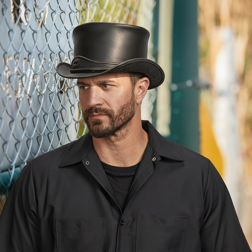 Man wearing a black top hat and black shirt against a blurred outdoor background