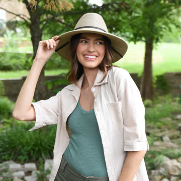 Woman wearing a wide-brimmed hat in a natural setting