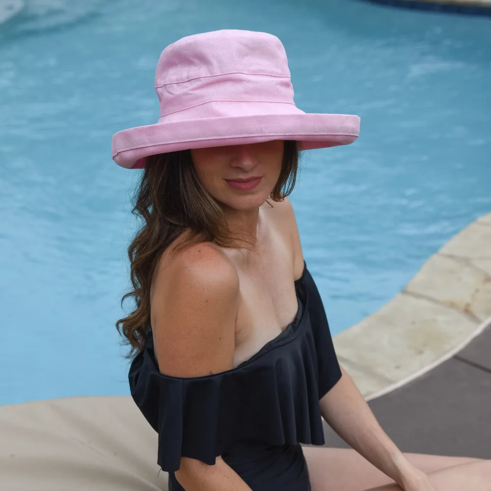 Woman wearing a pink hat by a pool