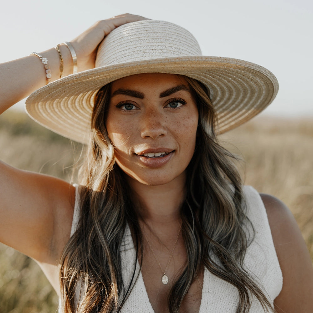 Woman wearing a wide-brimmed hat in a natural setting