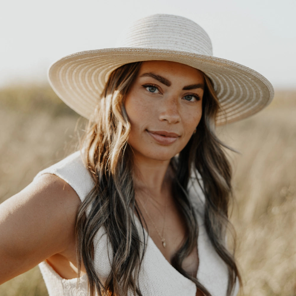 Woman wearing a wide-brimmed hat in a field