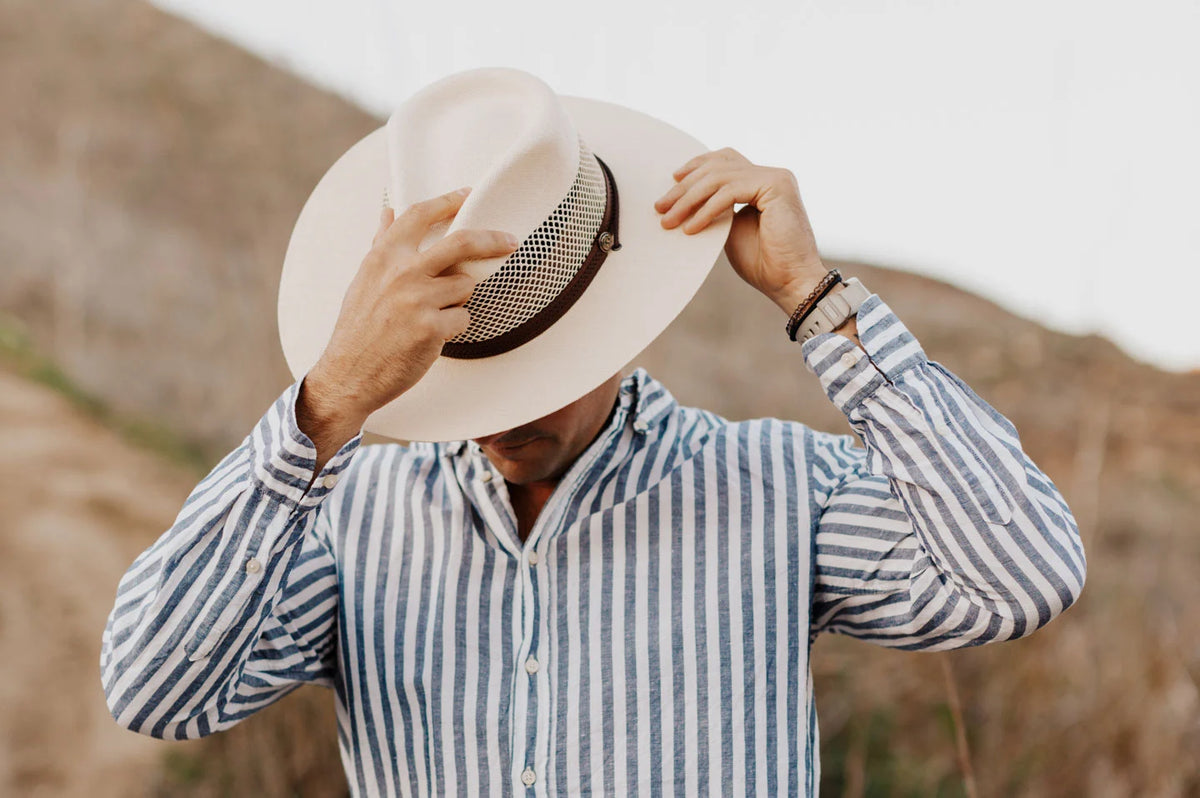 man in a striped shirt wearing a mens white straw sun hat by american hat makers