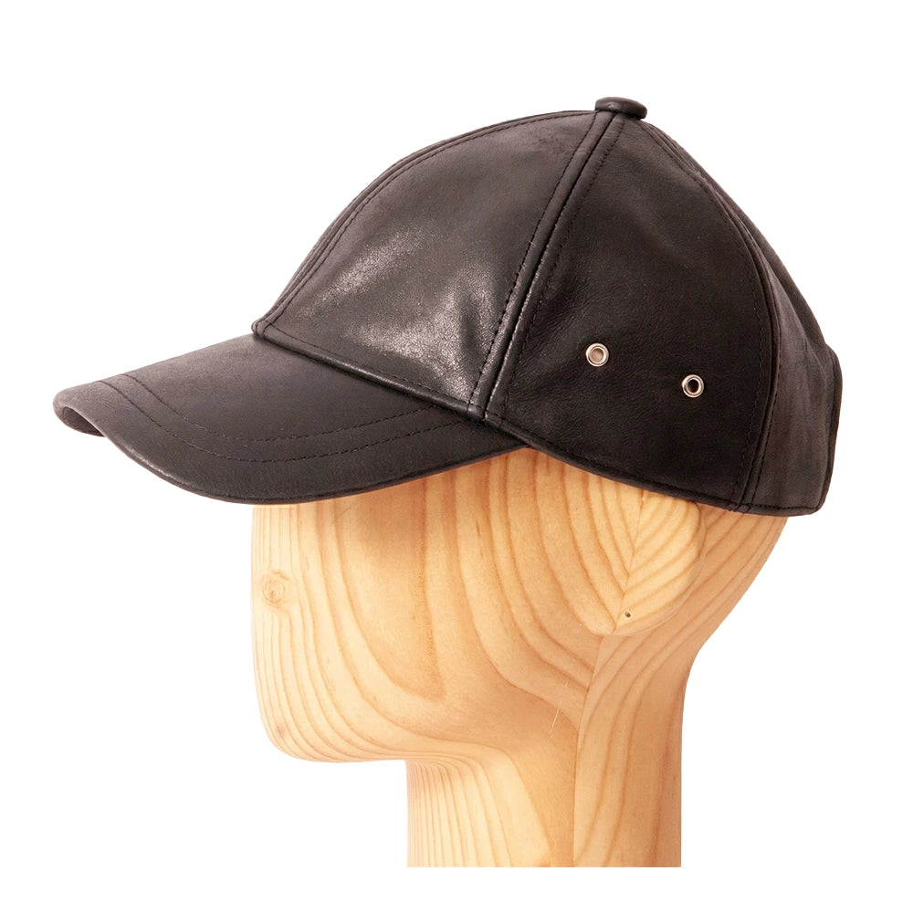 Black leather cap on a wooden mannequin head against a white background